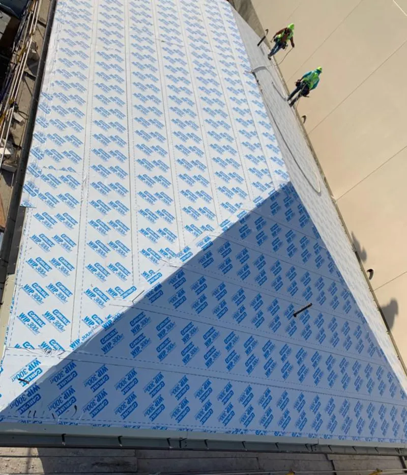 Professional roofers installing underlayment on a metal roof in Rio Rancho